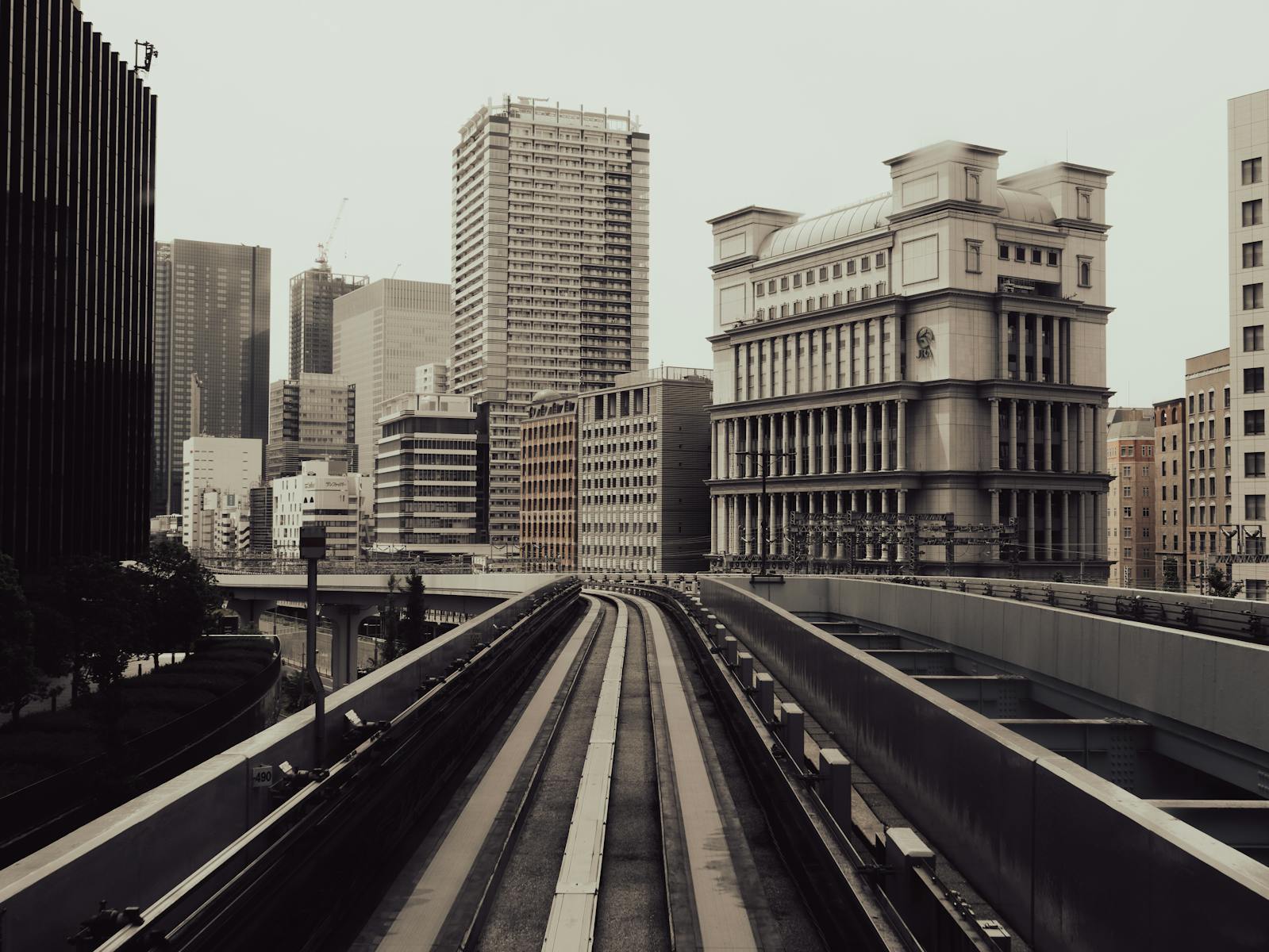 A view of urban railway tracks leading into the cityscape of Tokyo, Japan's architectural landmarks.