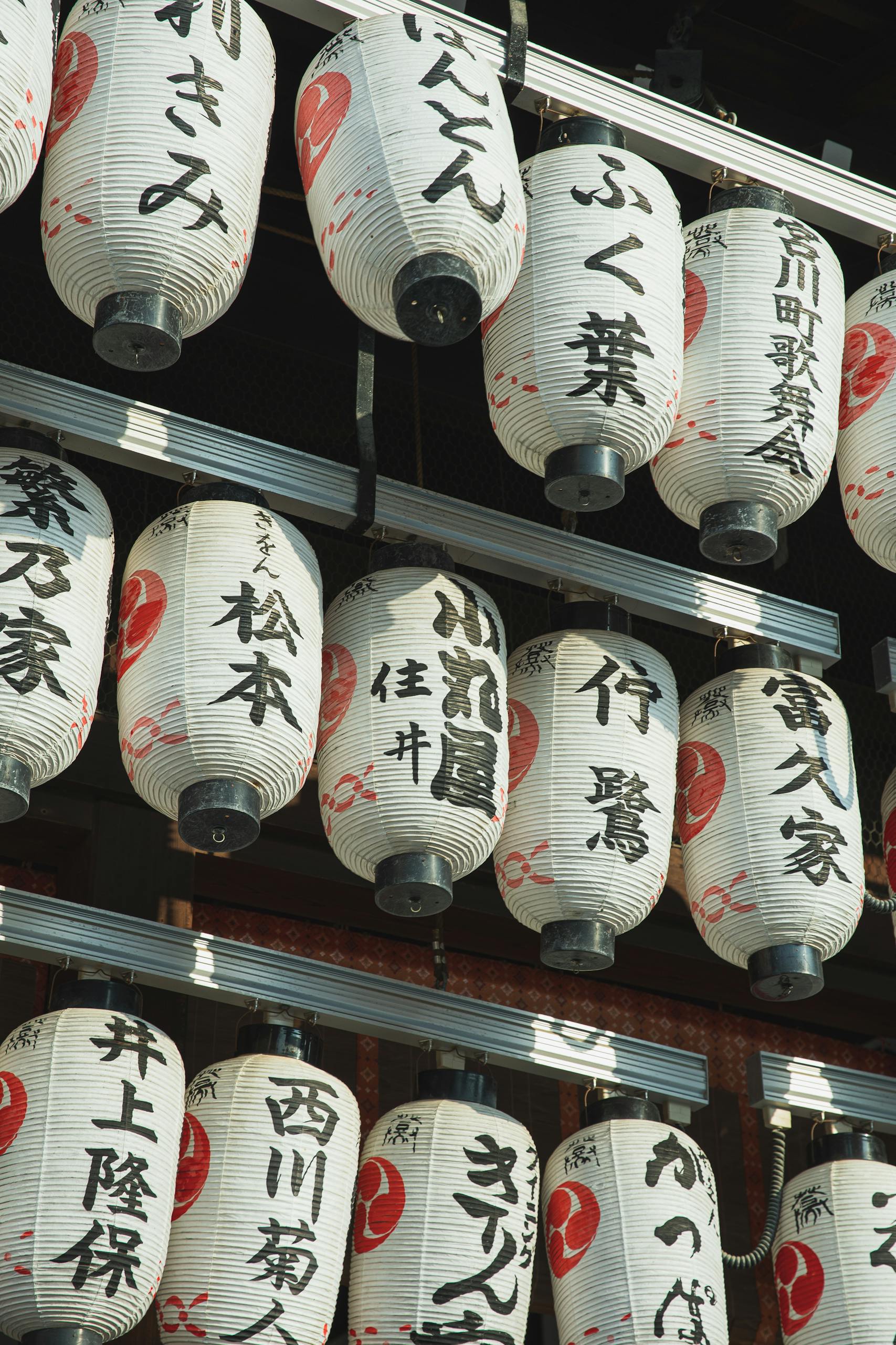 A collection of hanging Japanese paper lanterns showcasing traditional designs in Kyoto, Japan.