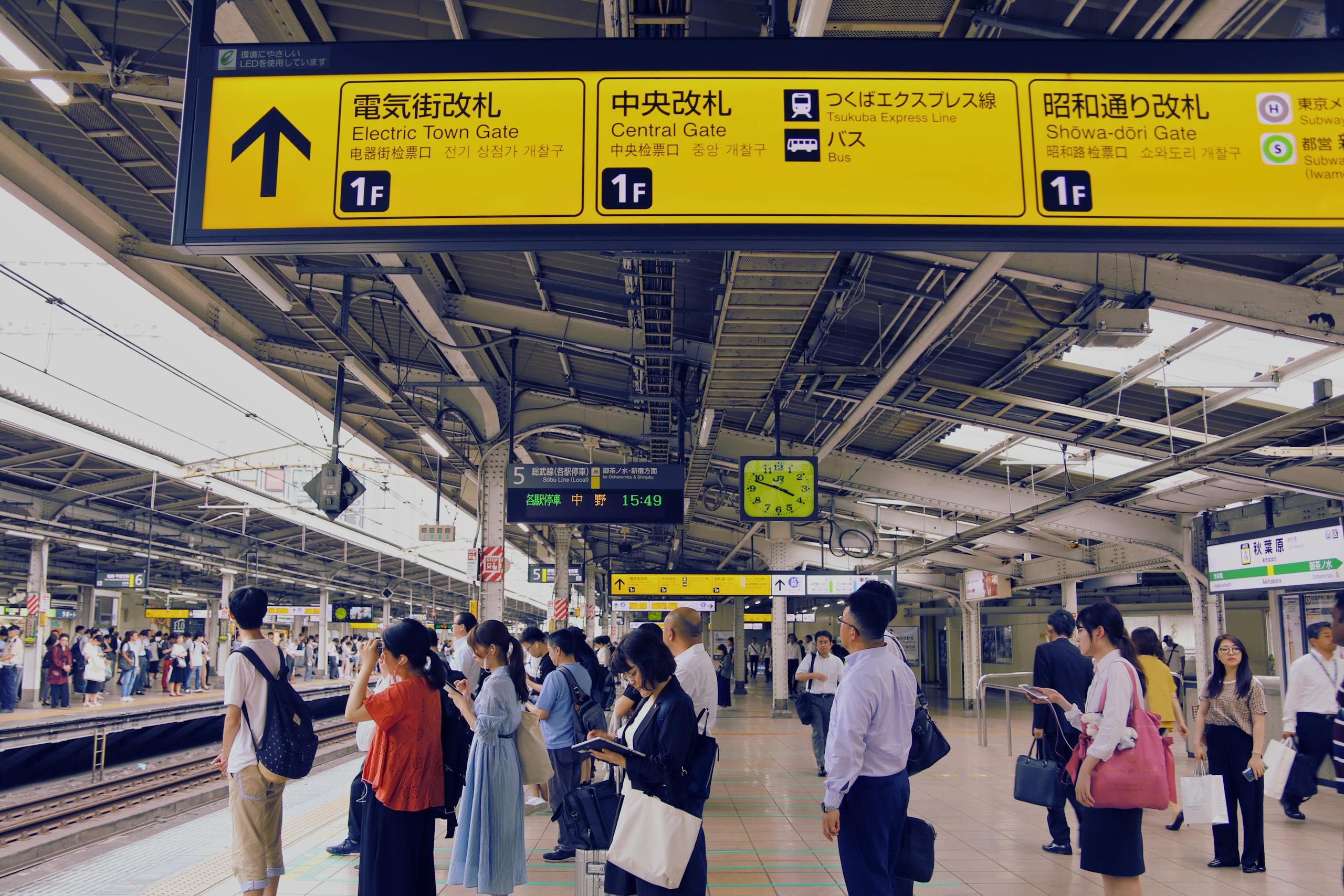 Commuters at a bustling train station in Tokyo, Japan, waiting for their train.